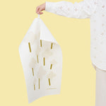 Kauniste ONNI linen-cotton tea towel with a look hung against yellow background