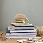 Lovi HEDGEHOG (4.4" / 11 cm) in natural wood color on top of books